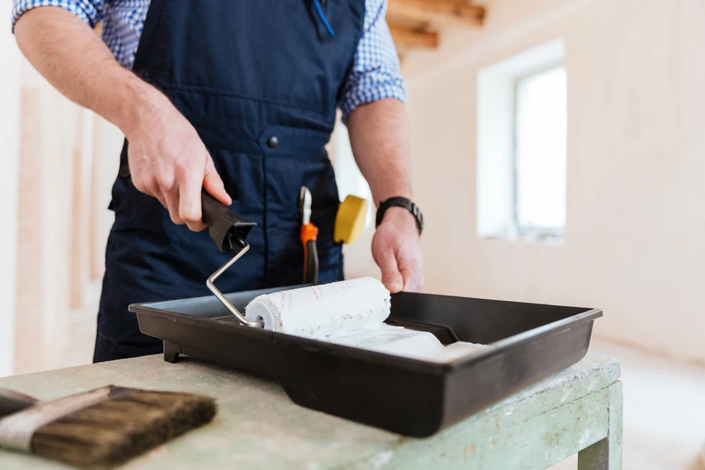 peintre homme, brosse à la main pour les produits pour restaurer et peindre le mur, intérieur le chantier d'une maison, mur pendant la peinture, rénovation, peinture, entrepreneur, Architecte, ouvrier de construction