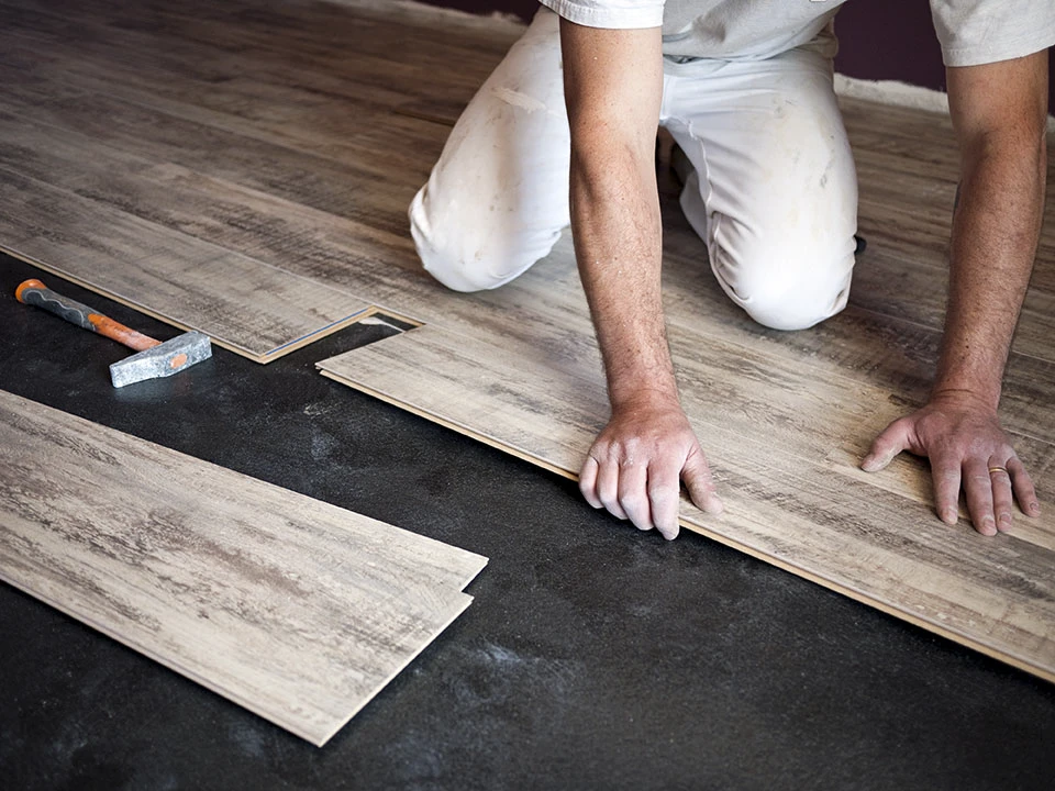 Ouvrier professionnel installant un nouveau parquet à l'intérieur, gros plan
