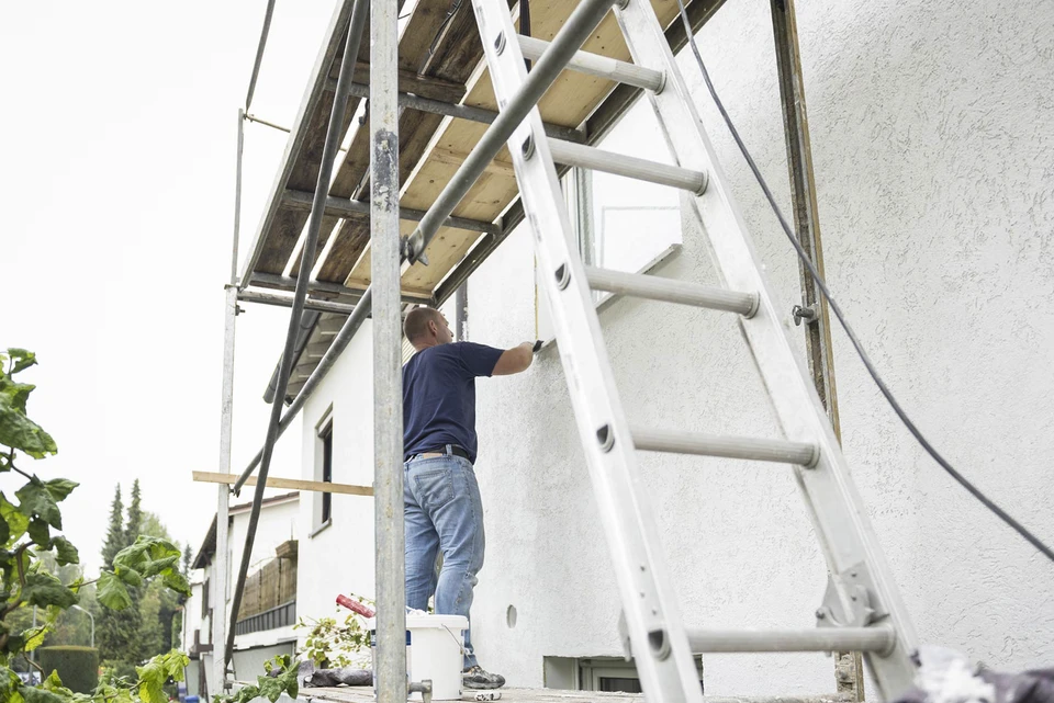 Homme travaillant sur une façade de maison